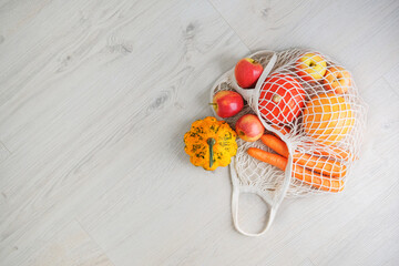 Zero waste eco friendly shopping concept, vegetables fruits in white mesh cotton, top view. Copy space. Sustainable lifestyle concept.