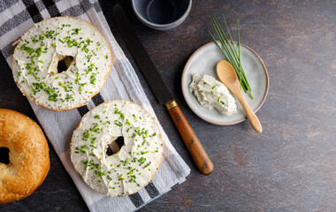 Breakfast table with bagels fresh cheese. Bagels with fresh cheese and herbs on a breakfast table ,...