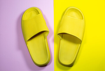 Yellow Summer Slippers on the yellow background. Pair of house indoors shoes. Minimalist, creative photo.