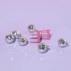Christmas creative layout with disco ball Christmas baubles and pastel pink chair on pastel purple...