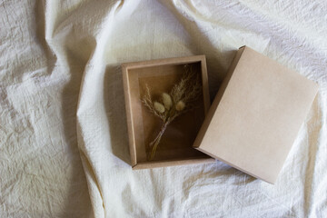 Nature flowers on brown box on white fabric. 