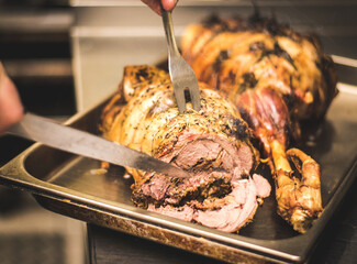 Detail of baked meat being cut with knife.