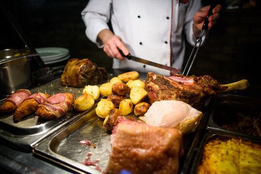 Detail of baked meat being cut with knife.