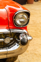 Fototapeta premium Front detail of the fender and headlight of the red chevrolet in havana (Cuba).