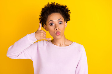 Photo of pretty dark skin people kiss lips arm fingers show call me gesture isolated on yellow...