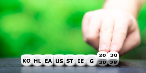 Symbol für den Kohleausstieg in Deutschland im Jahr 2030. Hand dreht zwei Würfel und ändert den...