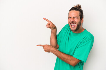 Young caucasian man isolated on white background excited pointing with forefingers away.
