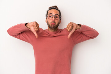 Young caucasian man isolated on white background showing a dislike gesture, thumbs down. Disagreement concept.