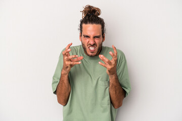 Young caucasian man isolated on gray background upset screaming with tense hands.