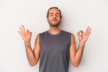 Naklejka premium Young caucasian man isolated on gray background relaxes after hard working day, she is performing yoga.