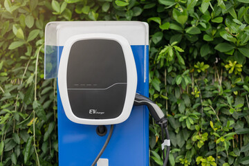 Electric car charging station for charge EV battery in car parking. Green power and future transport technology concept.