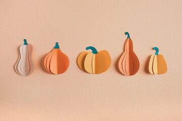 Pumpkins made from paper on pastel orange background. Halloween holiday concept, Thanksgiving day...