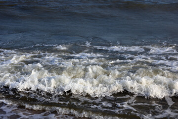 Beautiful seascape with beautiful sea waves and sea foam on shore with sea water on beach by sea