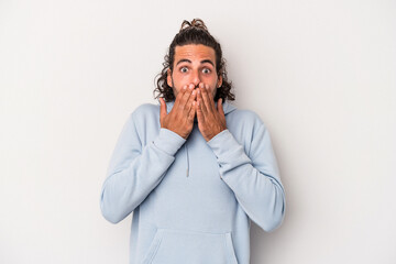 Young caucasian man isolated on gray background shocked covering mouth with hands.