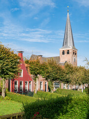 Fototapeta na wymiar Mauritiuskerk and waterside gardens on Eegracht canal in IJlst, Friesland, Netherlands