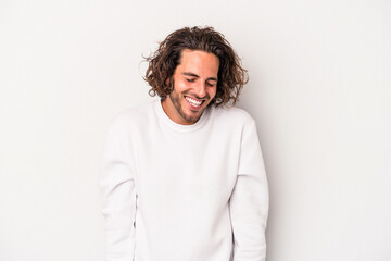 Young caucasian man isolated on gray background laughs and closes eyes, feels relaxed and happy.