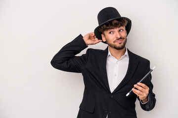 Young arab wizard man holding a wand isolated on white background touching back of head, thinking...