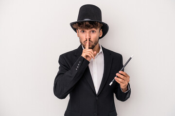 Young arab wizard man holding a wand isolated on white background keeping a secret or asking for...