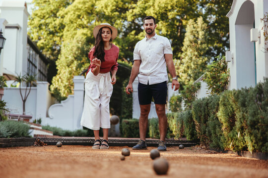 Tourist couple playing a game of bocce together