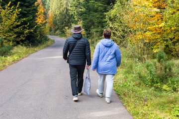 Man and woman walking together on a forest road.
