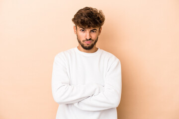 Young arab man isolated on beige background unhappy looking in camera with sarcastic expression.