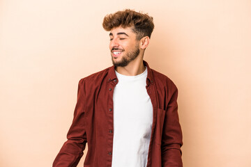 Young arab man isolated on beige background dancing and having fun.