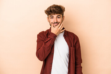 Fototapeta premium Young arab man isolated on beige background doubting between two options.
