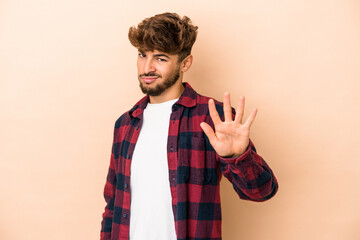 Young arab man isolated on beige background rejecting someone showing a gesture of disgust.