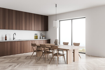 Minimalist dark wood kitchen with light wood dining table. Corner view.