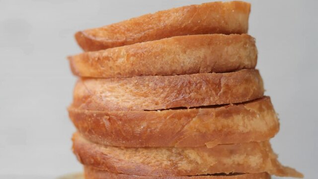 Toasted white bread in a stack on a light background closeup