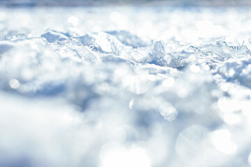 Ice surface texture with crystals and ice floes. Blurred Natural Background Ice floe breaking up against shore and glittering ice crystals on the surface of the river. Frozen river and transparent ice