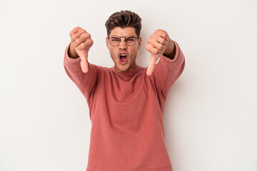 Young caucasian man isolated on white background showing thumb down and expressing dislike.