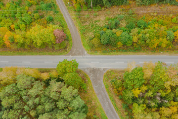 Skrzyżowanie drogi asfaltowej z drogą leśną. Widok z drona.