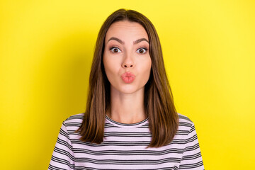 Photo of lovely millennial brunette lady blow kiss wear striped t-shirt isolated on yellow color background