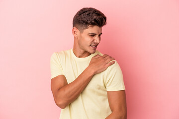 Young caucasian man isolated on pink background having a shoulder pain.