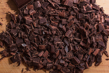 Chopped chocolate on wood tablet.