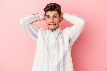 Young caucasian man isolated on pink background screaming with rage.