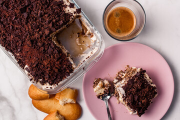 Top view of gourmet Tiramisu italian with a cup of coffee and a piece of cake served with copy space. Classic italian recipe.