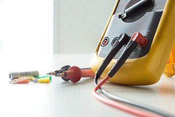 Selective focus Yellow Digital multimeter with probes on white background , A multimeter is an...