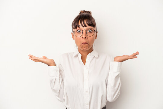 Young mixed race business woman isolated on white background  shrugs shoulders and open eyes confused.