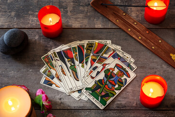 Tarot cards on wooden table with candles