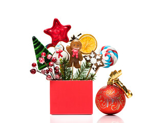 Winter concept with New Year decorations and sweets  isolated on a white background. Christmas festive card with Christmas gingerbread and candy on sticks in gift box.