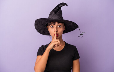 Young mixed race woman disguised as a witch isolated on purple background  keeping a secret or...