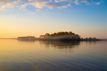 Beautiful island with fog at sunset. Summer landscape