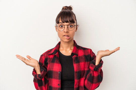 Young mixed race woman isolated on white background  confused and doubtful shrugging shoulders to hold a copy space.