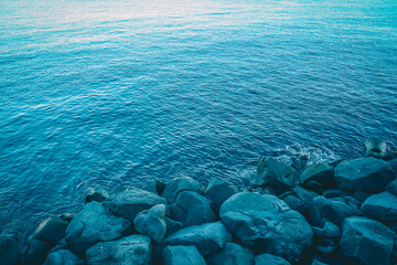 Rocks with the sea in the port of Naples, Italy