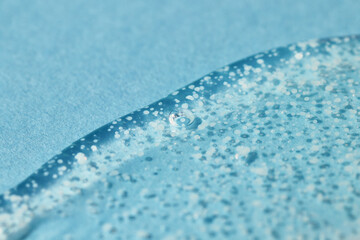 Smoothing scrub wash gel drop on blue background.