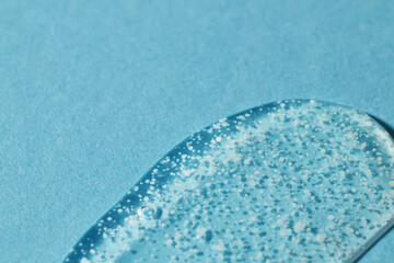 Smoothing scrub wash gel drop on blue background.