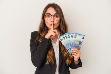 Young caucasian business woman holding banknotes isolated on white background keeping a secret or asking for silence.