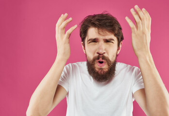 emotional man in white t-shirt studio pink background